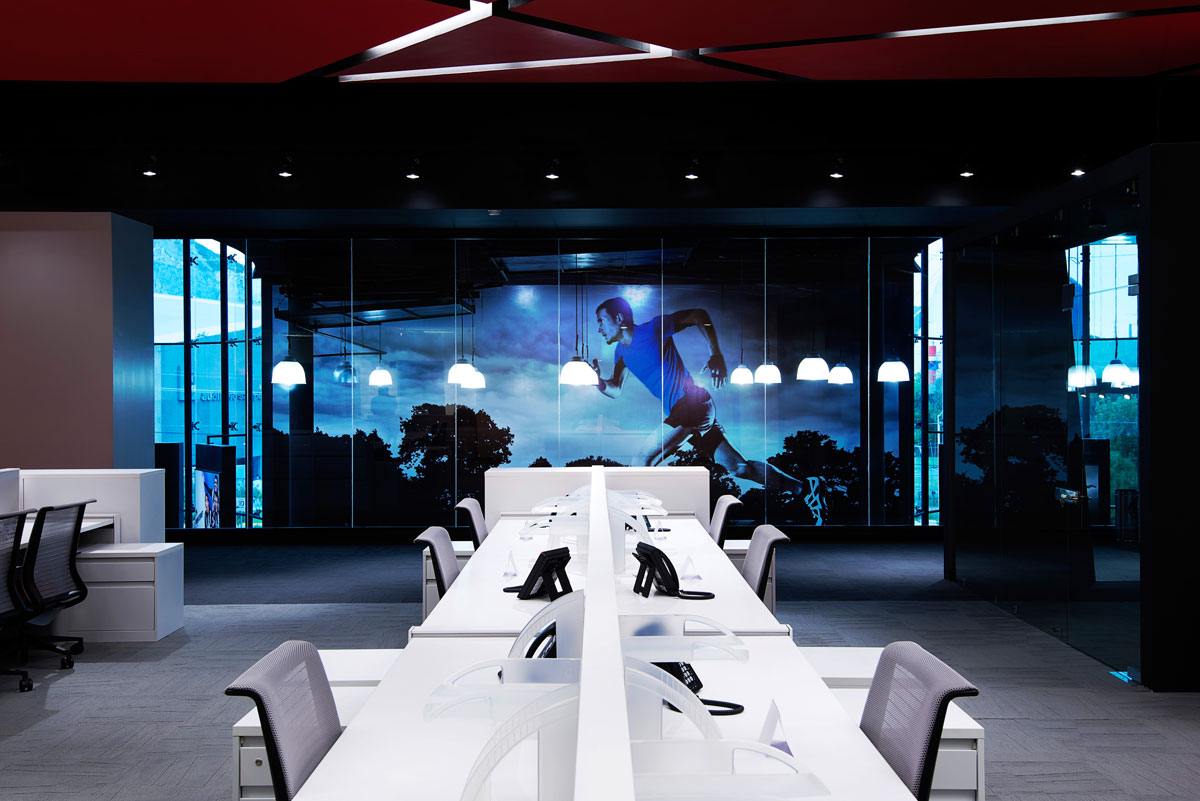 corporate office space desks with backdrop of man running